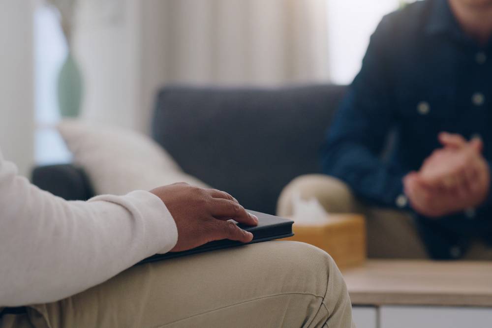 Close-up of two people engaged in a therapy session, illustrating supportive care during Heroin Detox in Orange County.