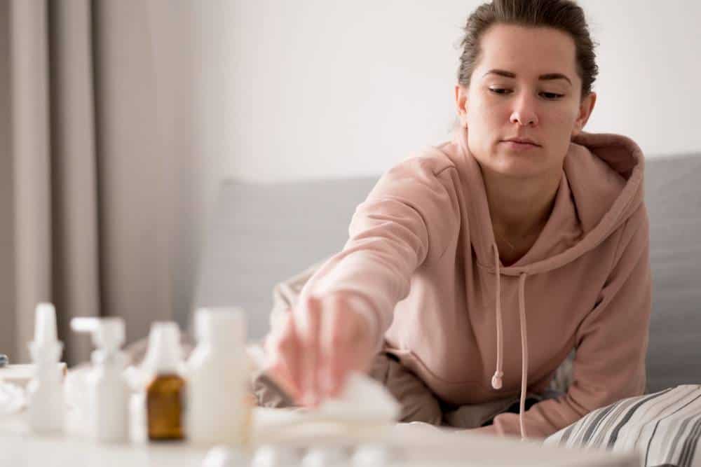 oman reaching for medication during treatment at a cocaine rehab in Orange County.
